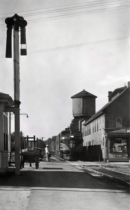 Wolfeboro Junction (now, Sanbornville, NH). Looking at Garvin Mercantile with railroad water tower in the background.